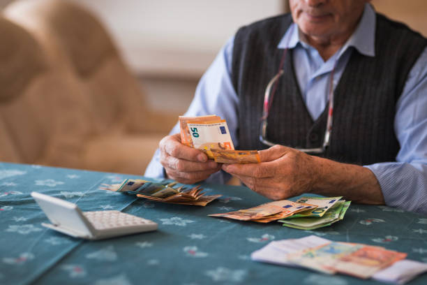 Elderly man counting euros at home, close-up Close-up of a senior man counting money in European Union currency financial item stock pictures, royalty-free photos & images