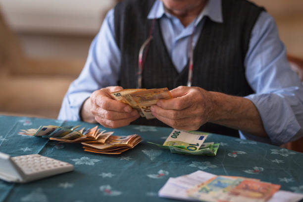 uomo anziano che conta euro a casa, primo piano - harsh conditions foto e immagini stock