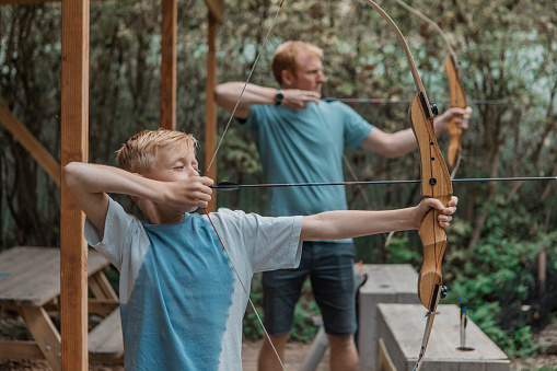 A father coaching a children's archery team