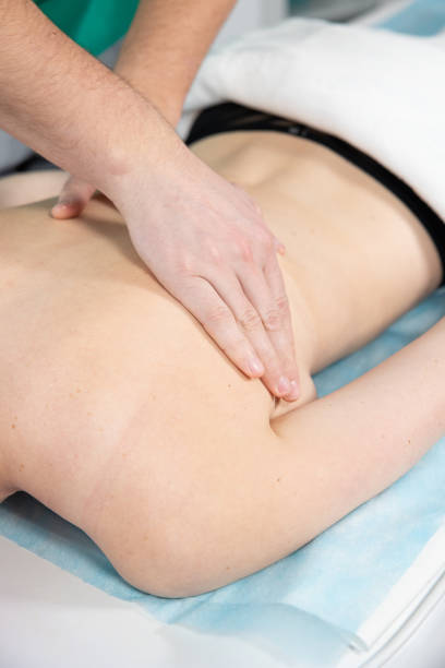 istock The masseur's hands massages the muscles on the woman's back. 1420164268