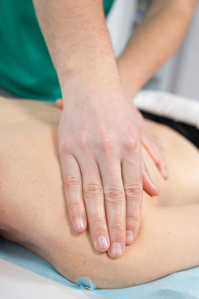 istock The masseur's hands massages the muscles on the woman's shoulder. 1420164332