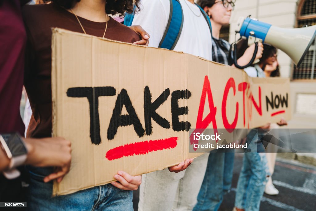 Multicultural teenagers standing up for equality and human rights Generation Z standing up for equality and human rights. Multicultural youth activists calling for action and change. Group of diverse young people protesting with a banner and a megaphone. Protest Stock Photo