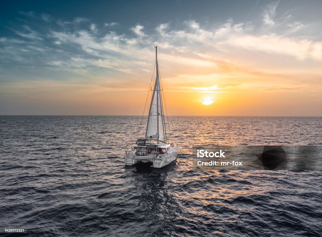 sailing catamaran caribbean bahamas turquoise water sunset Sailboat Stock Photo