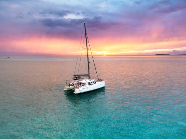 アンカー付きセーリングカタマランカリブ海バハマターコイズブルーの水の夕日 - sunset yacht luxury sailboat ストックフォトと画像