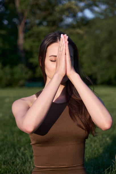 istock A young woman practices yoga while lying on a mat in the park. 1420174760