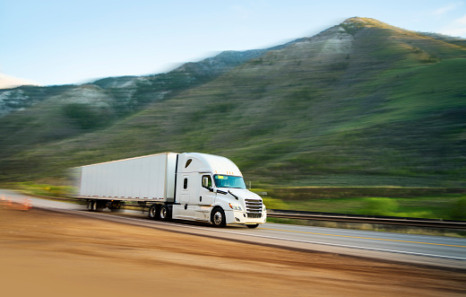 White semi-truck transporting merchandising - panning motion blur