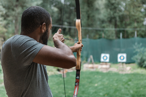 Black man trying archery