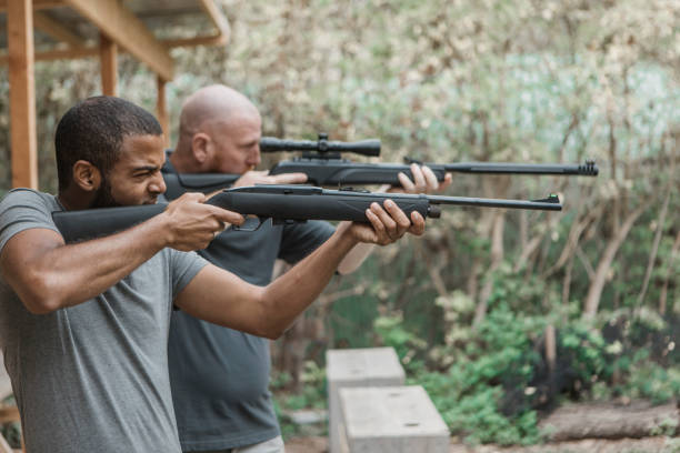 istock A redhead middle aged man trying rifle shooting with a younger black instructor 1420179380