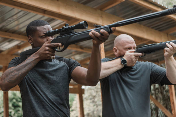 istock A redhead middle aged man trying rifle shooting with a younger black instructor 1420179408