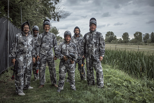 A middle aged mixed race male paintball team preparing for the game