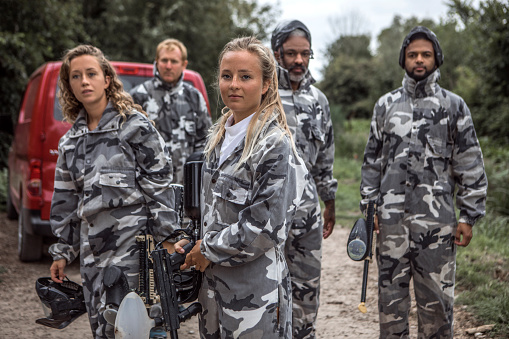 A mixed race, age and gender paintball team on their way to the field