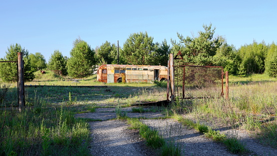 Dump of radioactive equipment. Rusty radioactive abandoned bus. Chernobyl exclusion zone. Ukraine