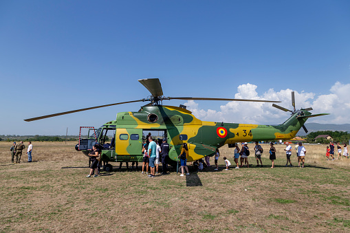 Stanesti, Gorj, Romania – August 27, 2022:  Unidentified people visit the IAR 330 Puma SOCAT helicopter at the air show at the Stanesti aerodrome, Gorj, Romania