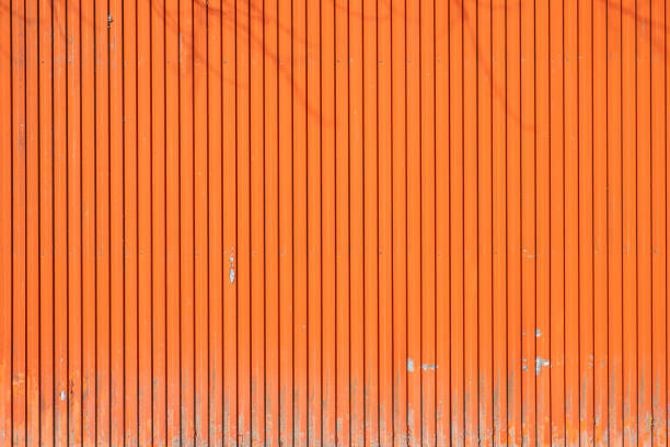 istock Large painted orange metal door in a warehouse, security concept 1420184084
