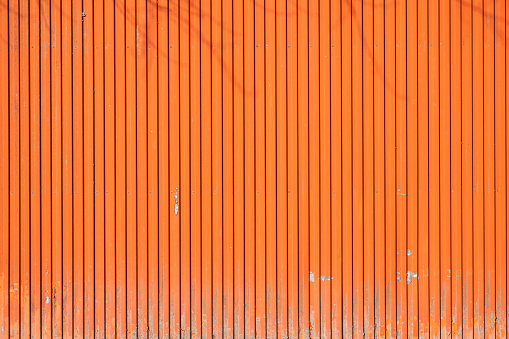 Large painted orange metal door in a warehouse