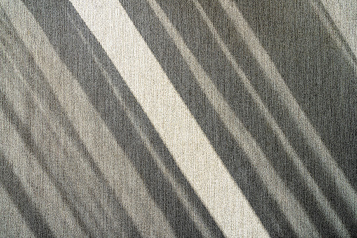 Oblique light and shadow on the grey fabric.