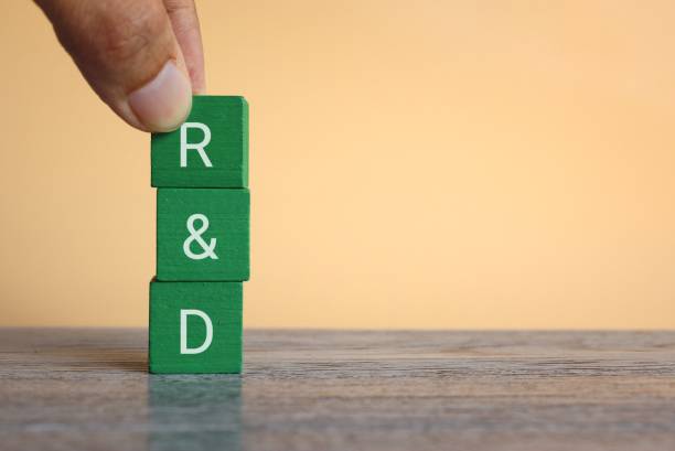 istock Hand holding wooden cubes with text R and D 1420186238