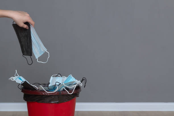 istock Throw a black medical protective mask into a red trash can 1420188414