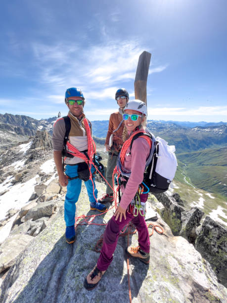 istock Three mountaineers people on mountain peak, success on top 1420189102