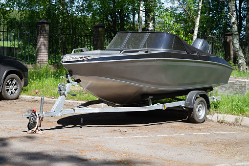 A boat or a boat with a motor on a trailer with wheels for transportation by car with a trailer.