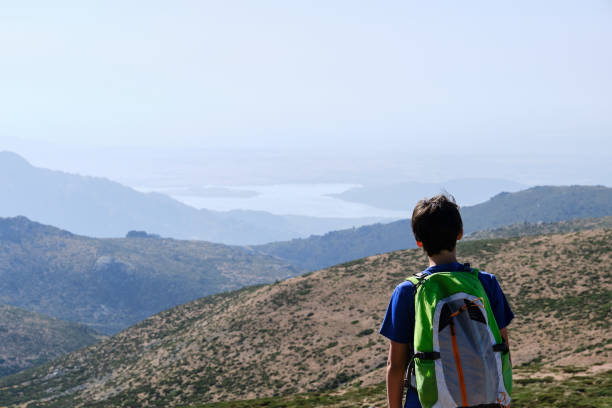 istock Teenager with backpack admiring mountains in summer 1420196203