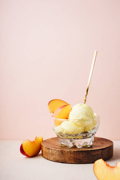 Glass of peach ice cream with a spoon.