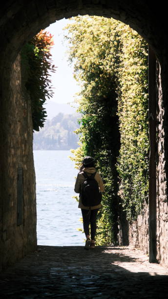 a girl under the ancient green arch of stone on the como lake, italy. - european culture ancient architecture still life imagens e fotografias de stock