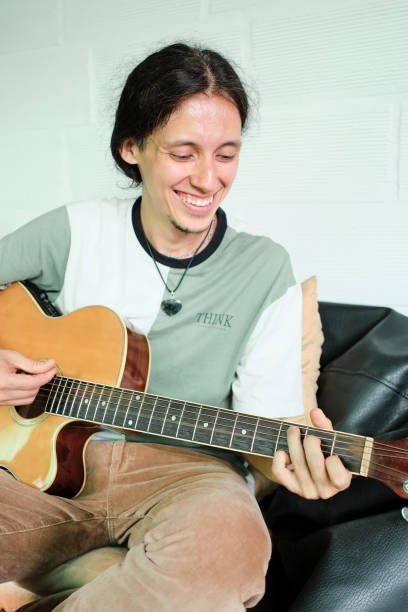 istock Smiling musician playing guitar 1420202633