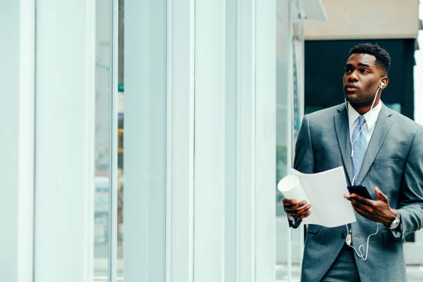 istock Young entrepreneur using smartphone outside wearing suit 1420205290