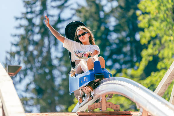 istock Girl is going across the bridge on a mountain roller coaster with outstretched arm 1420205665