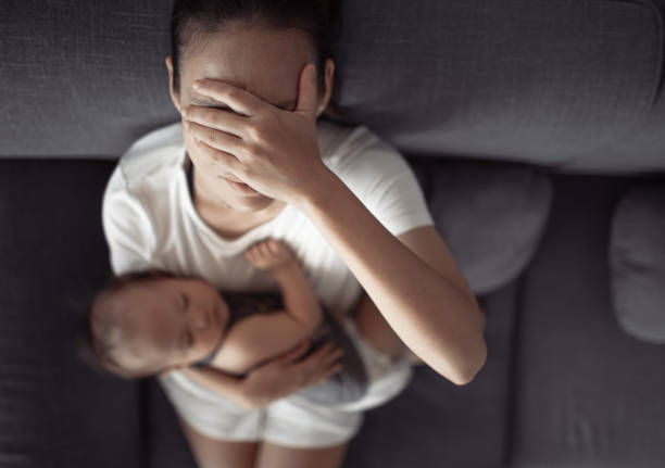 mãe cansada com dor de cabeça, estressada com bebê em casa - depression sadness women distraught - fotografias e filmes do acervo