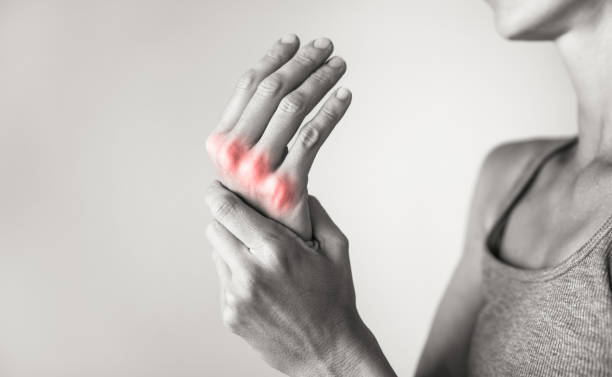 Donna che soffre di dolore alle mani e alle dita, infiammazione dell'artrite. - foto stock