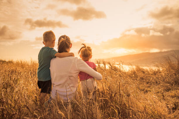 die alleinerziehende mutter und ihre beiden kinder verbringen zeit in der natur. glückliche liebevolle familie. - photography looking three people mother stock-fotos und bilder