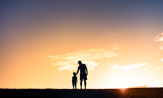 Father, child and holding hands on shoulder for happy relationship, bonding and smile in the outdoors. Portrait of dad and kid smiling in happiness for love, blue sky or care for piggyback in nature