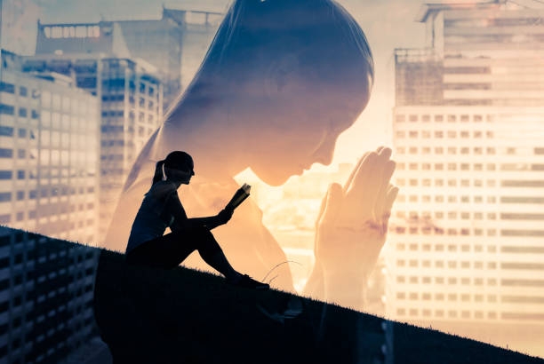 istock Woman praying and reading bible. 1420209104