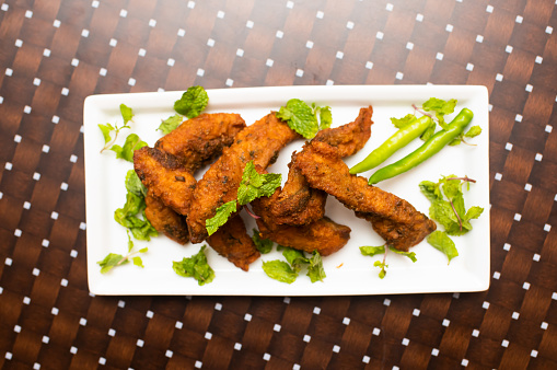 Amritsari fried fish or Macchi Fry served in a dish isolated on table background top view of bangladesh food