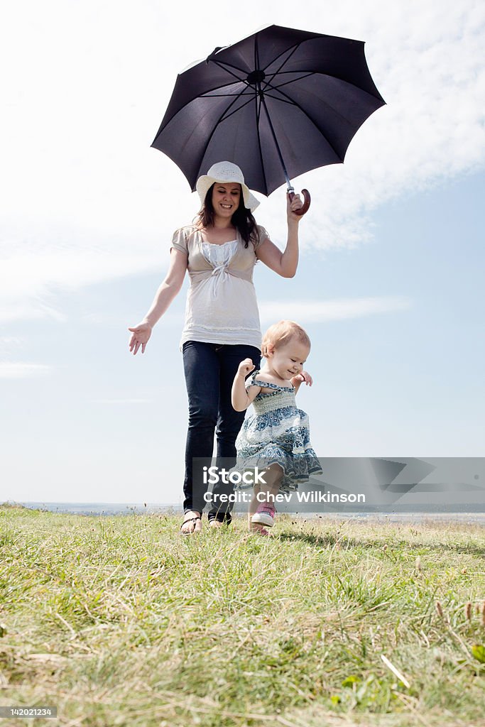 Woman with daughter and umbrella  12-17 Months Stock Photo