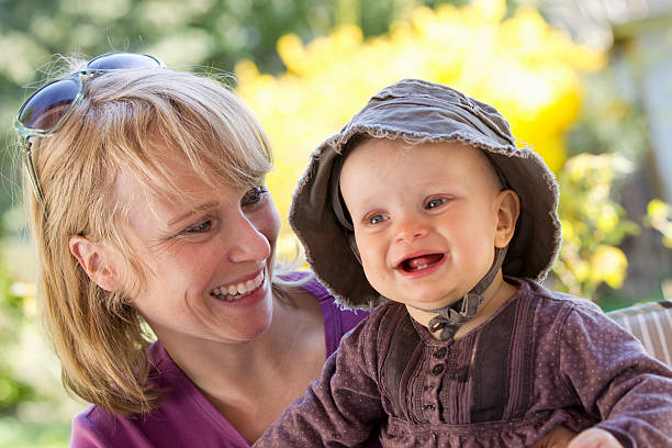 lächelnde frau hält baby mädchen - @jackstar stock-fotos und bilder