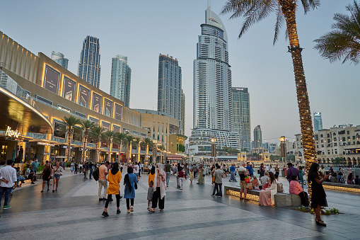 Dubai, United Arab Emirates - May 30, 2022: tourists walking and relaxing at the large terrace outside the Dubai Mall.