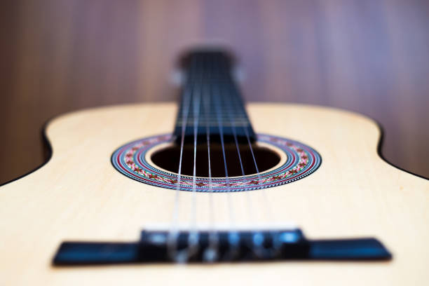 istock Classical guitar stands on wooden background. 1420216757
