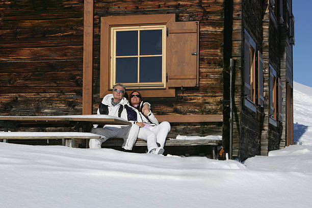 casal relaxante ao ar livre com ski chalé - fey imagens e fotografias de stock