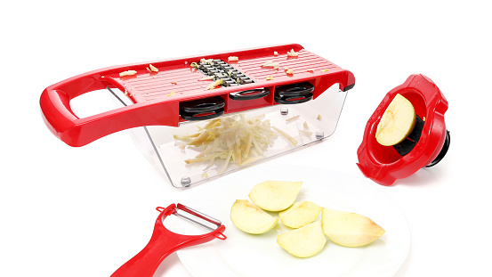 Multifunctional grater for vegetables and fruits with interchangeable blades isolated on a white background