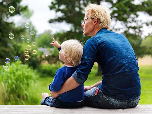 ojciec i syn podziwiając pęcherzyki na zewnątrz - preschooler child offspring purity zdjęcia i obrazy z banku zdjęć