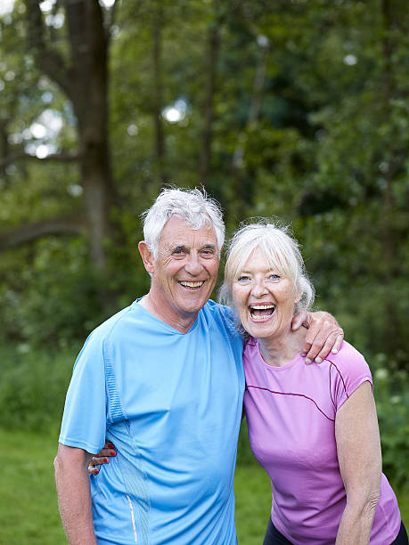 couple de retraités rire ensemble dans le parc - nordic running photos et images de collection