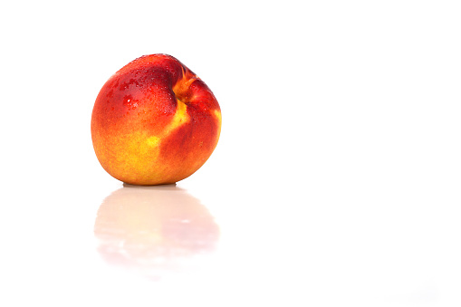 nectarine and water drops on white background