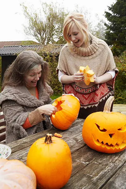 Photo of Mother and daughter carving pumpkins