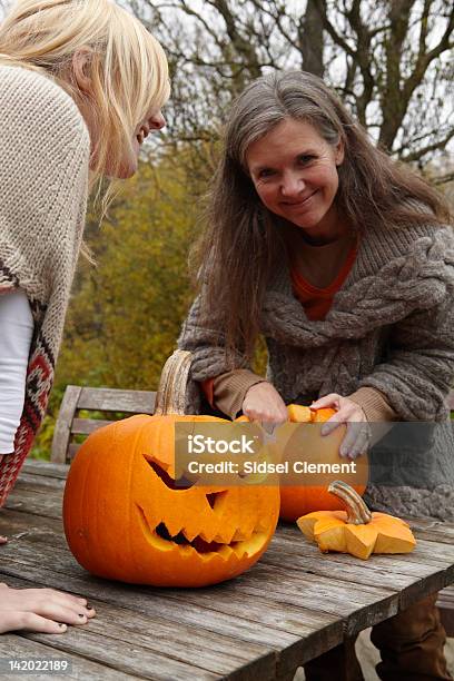 Mother And Daughter Carving Pumpkins Stock Photo - Download Image Now - Women, Halloween, Autumn