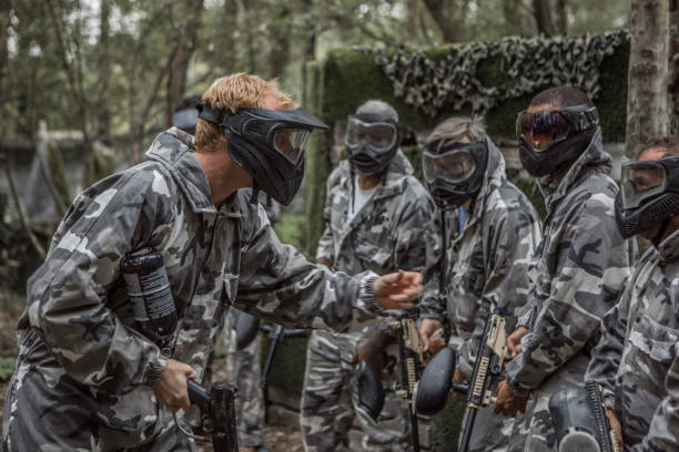 istock A mixed race middle aged male paintball team in action 1420224641