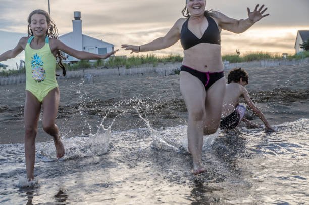 istock Mother and daughter running into the Atlantic Ocean 1420225820