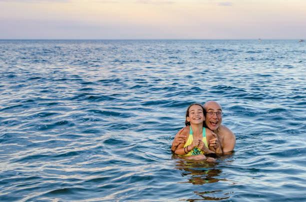 Father holding his daughter in the Atlantic Ocean stock photo